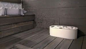 White Tulikivi Halla integrated into dark waxed sauna benches, close-up