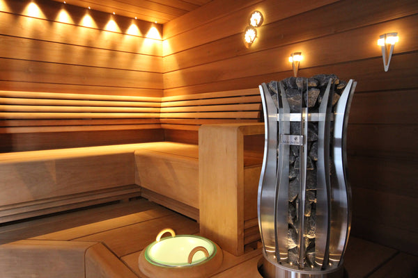 Wooden sauna interior with a metallic vase on a wooden shelf.