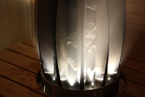 Decorative lamp with ribbed glass shade on a wooden surface