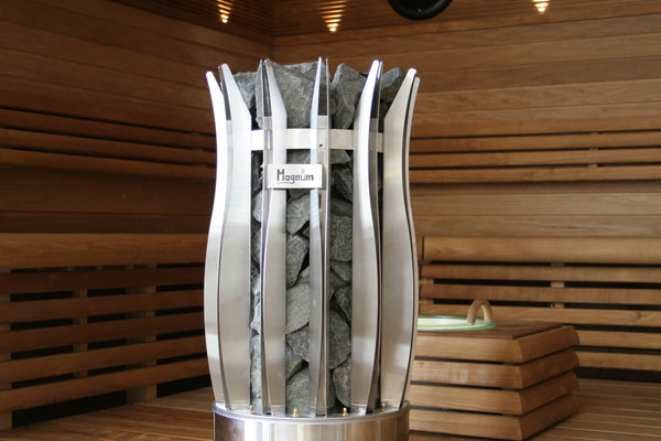 Metallic sauna stove with stones inside, set against a wooden sauna background.