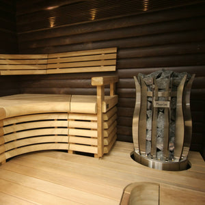 Wooden sauna interior with curved bench and stone-lined sauna heater.