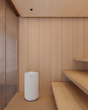 White electric sauna heater in a room with wooden walls and ceiling.
