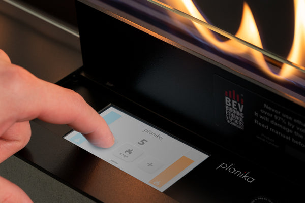 Close-up of Planika FLA4 ethanol burner touch display with flame height control and BEV Technology panel visible