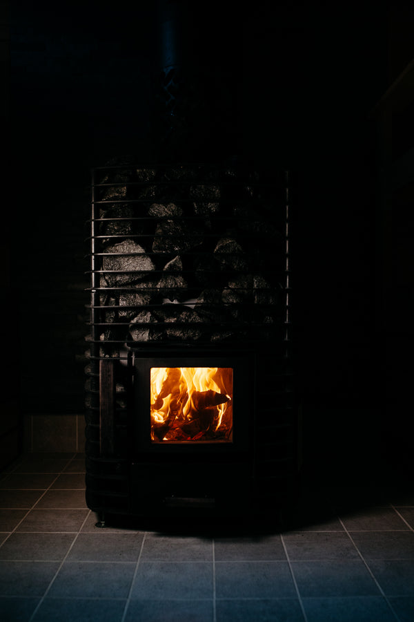 Wood-burning stove with flames visible in a dark room