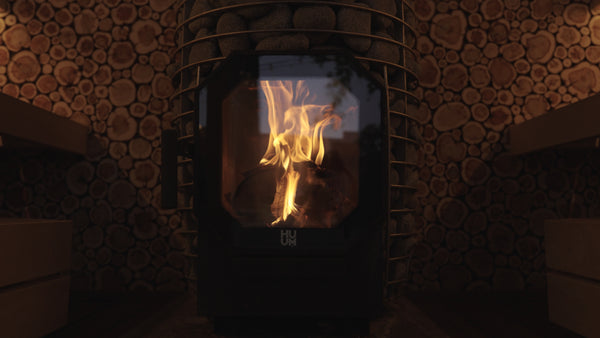 HUUM wood burning sauna heater with grey stones in a wooden sauna
