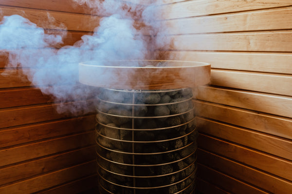 Wooden sauna with steam rising from an electric sauna heater