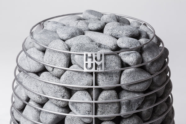 HUUM electric sauna heater filled with gray stones on a white background