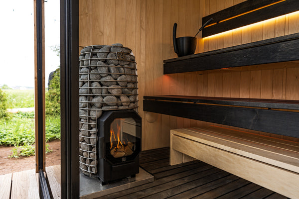 HUUUM Hive Flow Mini wood burning sauna heater with grey stones in a wooden sauna