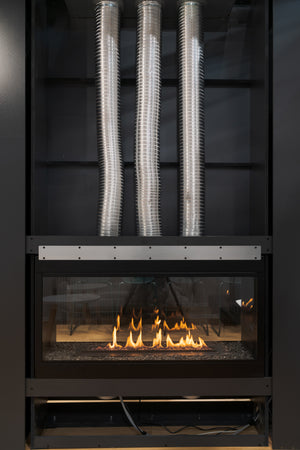 Modern fireplace with metal ductwork on a dark background