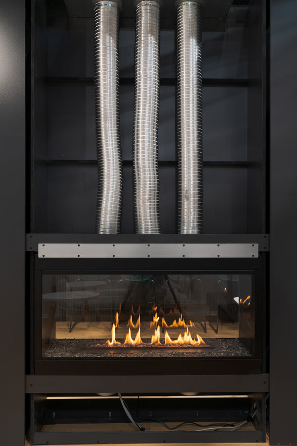 Modern fireplace with metal ductwork on a dark background