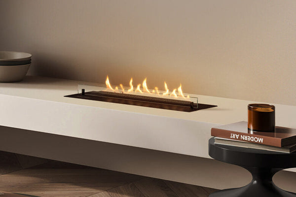 Planika NEO bioethanol burner inked into a long white table stand  with a pile of books next to it
