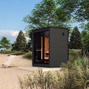 Saunum Classic Mini-Mini sauna cabin with wooden interior on a grassy beach with trees and a clear sky.
