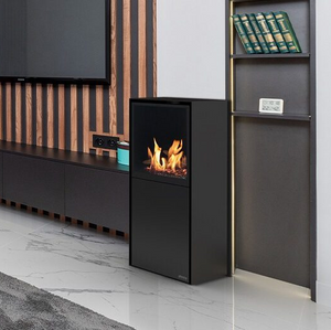 Side angle of Planika Scandi free-standing bioethanol fireplace next to a media wall with a TV and wooden wall paneling.