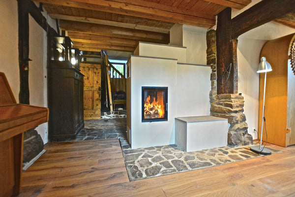 Modern Schmid 45 fireplace with surround in a room with wooden floors and exposed beams.