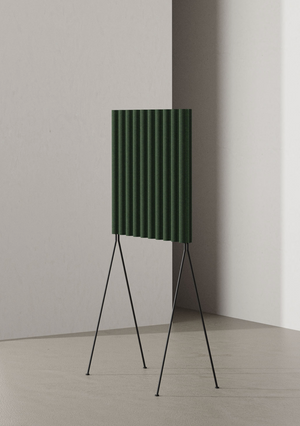 Green speaker on a stand against a plain wall