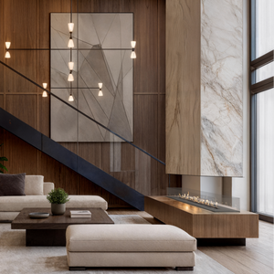 Modern living room with a staircase, sectional sofa, and decorative wall art.