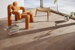 Light wood floor with large windows in the background