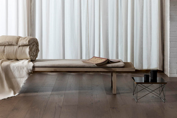Wooden flooring with a wooden bench, coffee table and beige colour blanket 