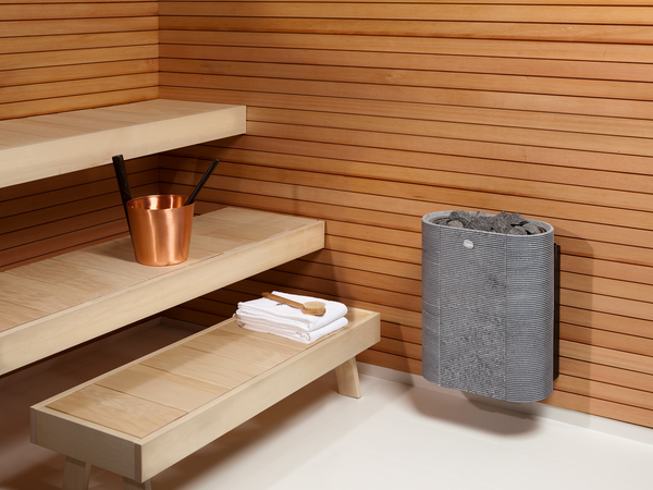 Soapstone cladded electric sauna heater Tulikivi Routa mounted on to sauna wall. 