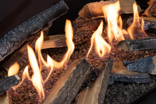 Close-up of burning logs with flames in a fireplace