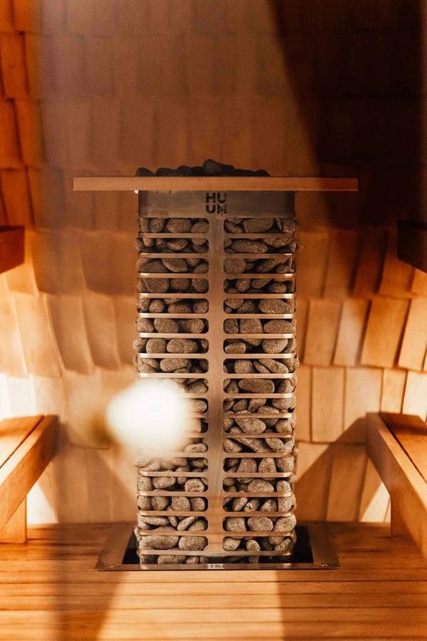 HUUM electric sauna heater filled with stones in a wooden sauna