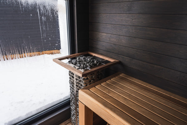 HUUM electric sauna heater filled with stones in a wooden sauna