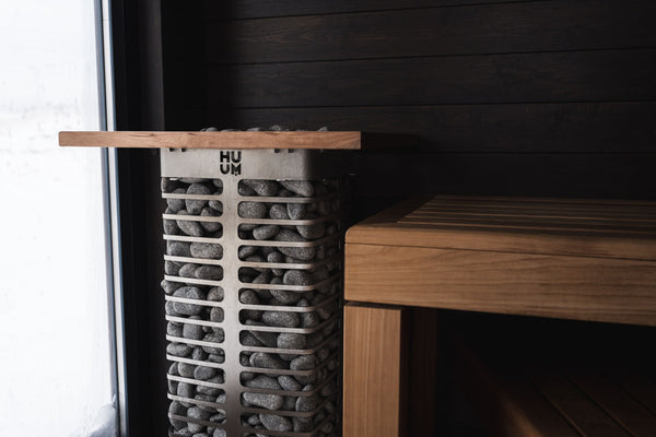 HUUM electric sauna heater filled with stones in a wooden sauna