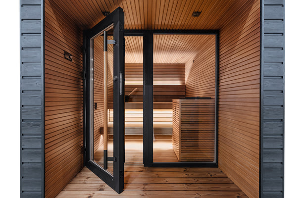 Wooden sauna with open door revealing interior benches and lighting fixtures.