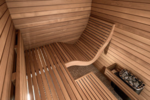 Wooden sauna interior with bench and rock holder.