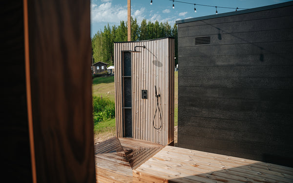 Outdoor shower with wooden enclosure in a natural setting