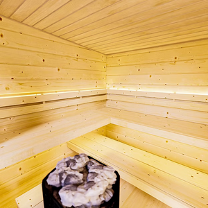Wooden sauna with benches and a stone heater.