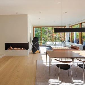 Modern living room with a fireplace, dining table, and chairs.