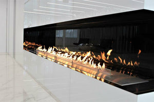 Long built-in linear bioethanol fireplace with glass panel and continuous flame in a modern interior