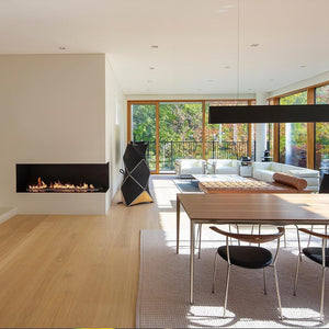 Modern living room with fireplace, dining table, and large windows.