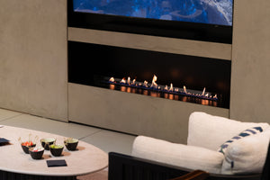 Modern living room with a gas fireplace and decorative items on a table.
