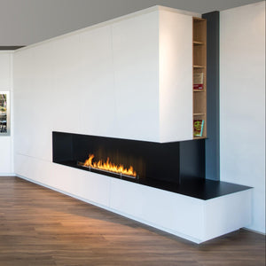 Modern living room with a white sofa, fireplace, and bookshelves.