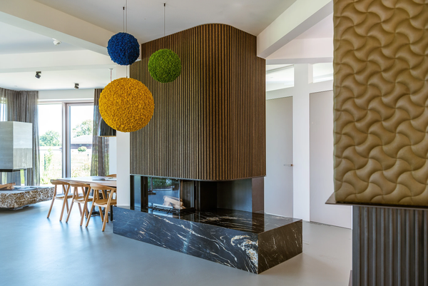 Modern living room with a fireplace, colorful spherical decorations, and a textured wall panel.