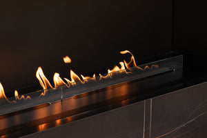 Modern ethanol fireplace with flames against a dark background