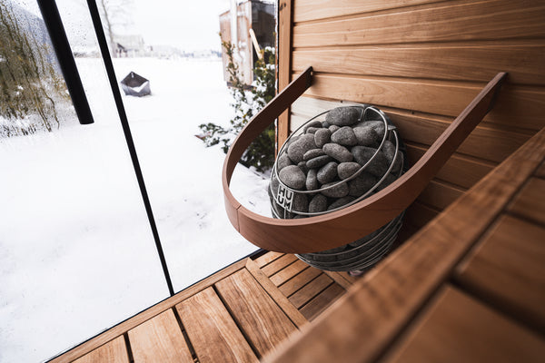 Wooden sauna with a sauna heater on a snowy day