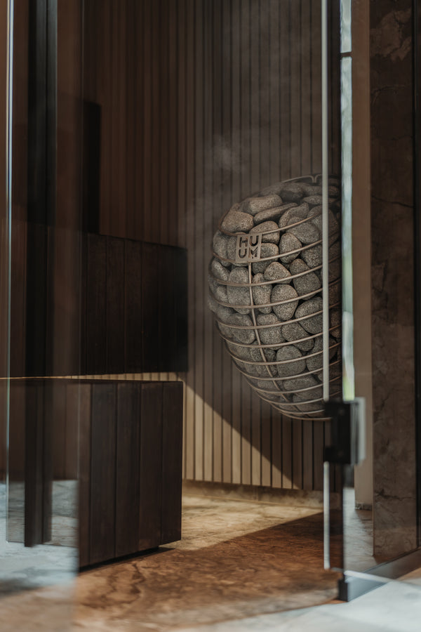 Modern sauna heater with a textured wall and glass door