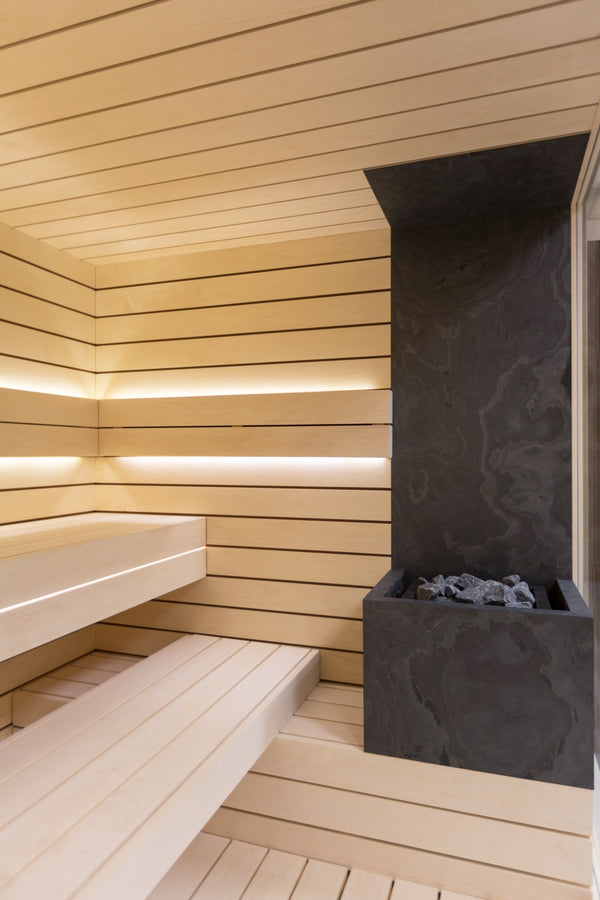 Wooden sauna interior with black stone bench