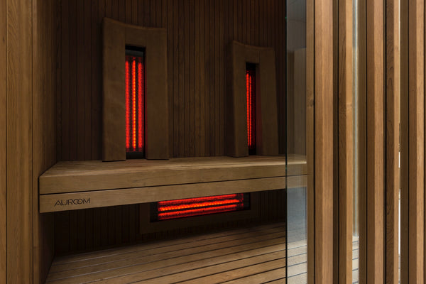 Infrared sauna with wooden interior and red light panels, featuring the brand 'Aurora'.