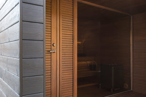 Wooden sauna door with gray exterior wall