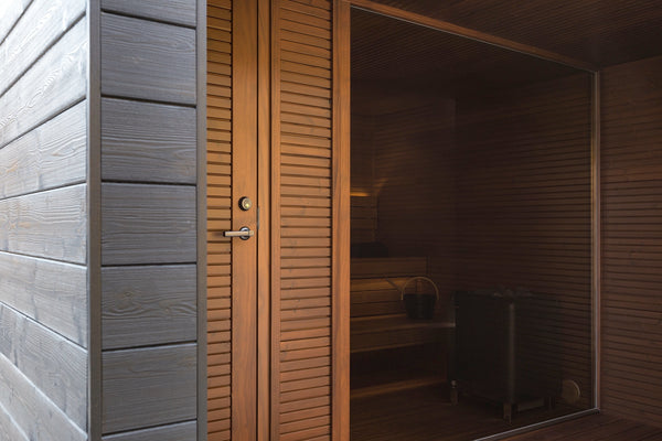 Wooden sauna door with gray exterior wall