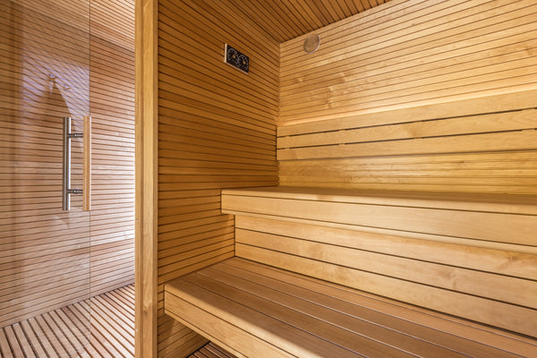 Wooden sauna interior with bench and glass door.