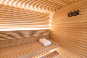 Wooden sauna interior with a bench and towels