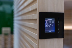 Digital temperature control panel on a wooden wall