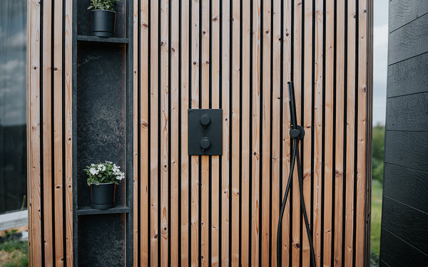Wooden outdoor shower with shelves and plants