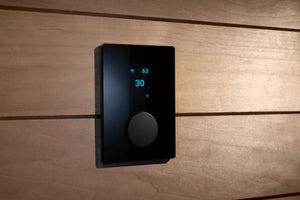 Black digital thermostat on a wooden wall
